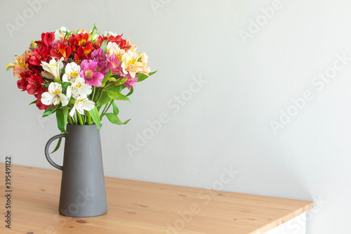 Wallpaper Mural Colorful flowers in a cement vase on a wooden table in grey room with copyspace Torontodigital.ca