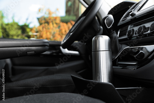 Silver thermos in holder inside of car