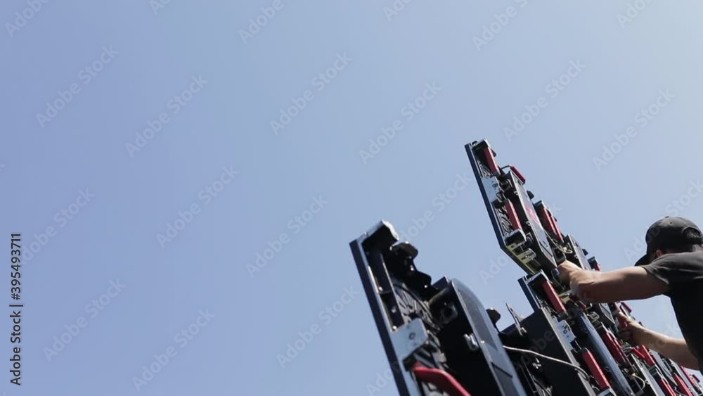 A man assembles LED panel elements, assembling a large LED screen. Free space for text on the side