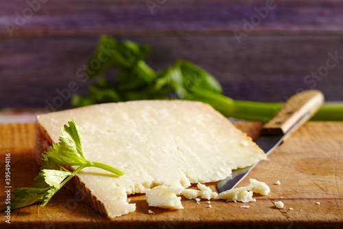 Pecorino sardo, hard cheese made from sheep's milk (Sardinia) on a wooden board with a knife photo