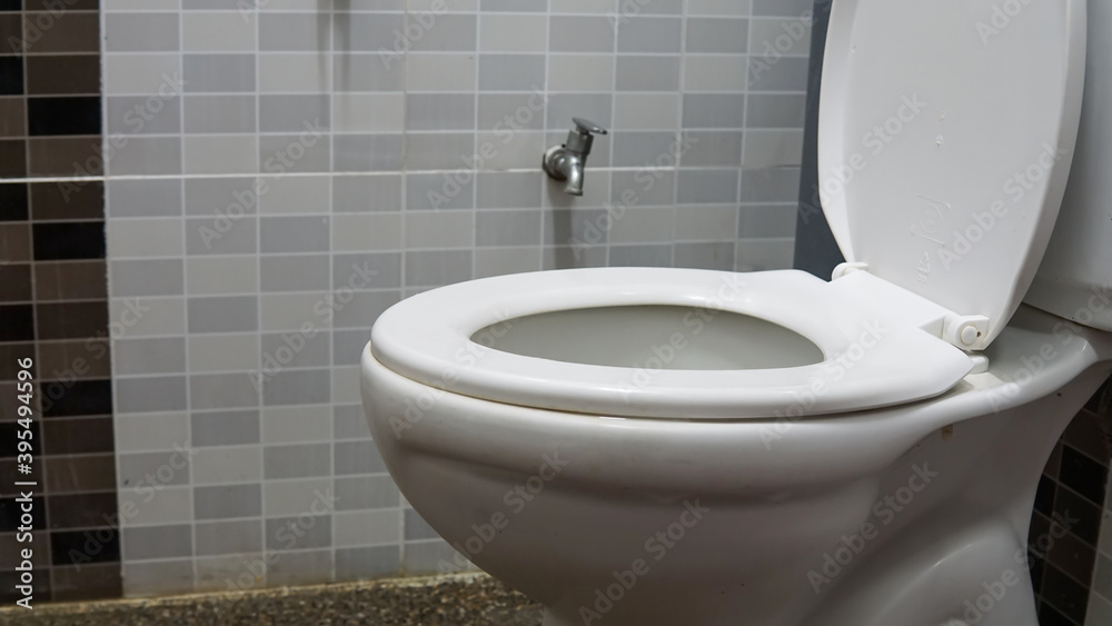 Fototapeta premium White toilet bowl seat in a modern interior design bathroom with pebble wash tiles floor.