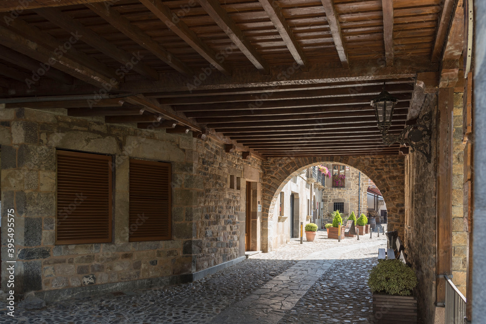 Cobblestone walkway tunnel with an arched entryway in Potes, Cantabria, Spain