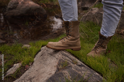 Woman wearing stylish hiking boots on rock, closeup