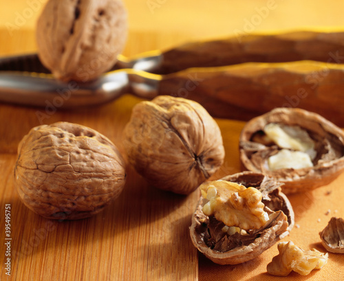 Walnuts (Juglans regia), whole and opened, with a nutcracker photo