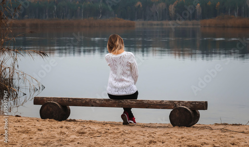 Young lady sits on the lake berigu and looks at the lake photo