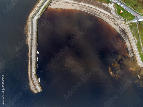 Aerial drone view on a Spiddal stone pier. County Galway, Ireland. Top down view. Small yachts and boats by the pier.