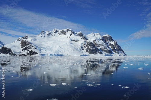 The blue sky shows radial clouds, icebergs and deep blue sea. These are the characteristics of Antarctica's summer.