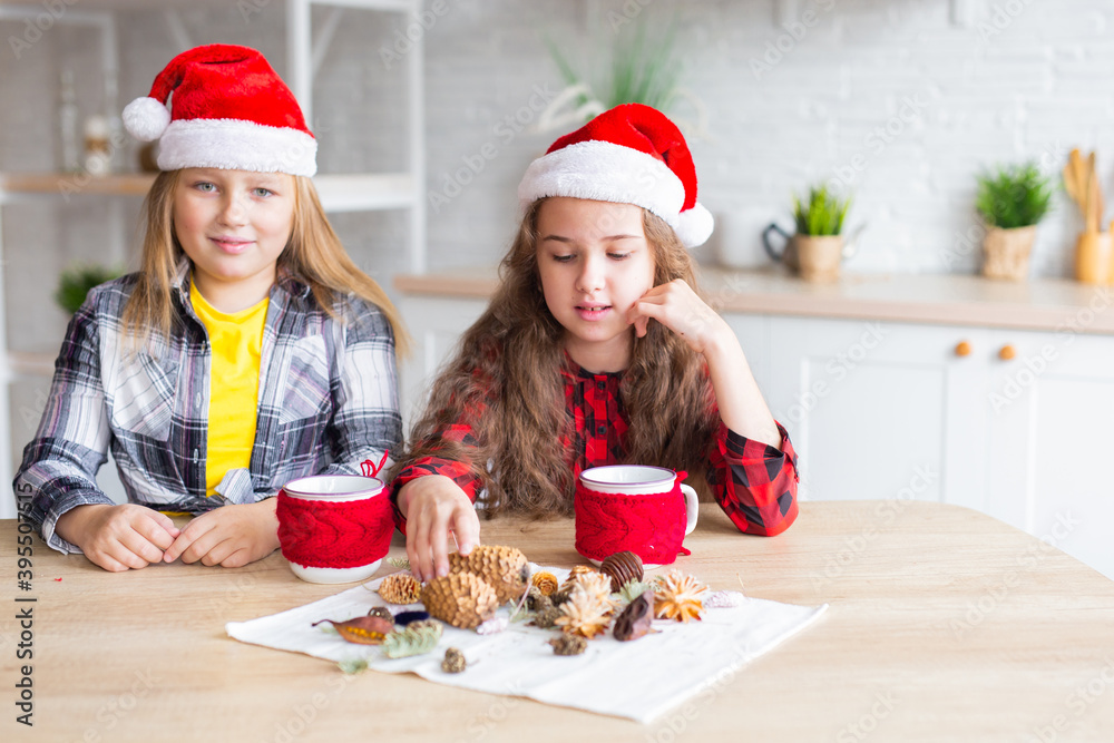 Merry Christmas and Happy Holidays! Cheerful cute kid girls having fun. Children in Santa hats have fun at breakfast in the morning. Loving family Merry Christmas and Happy Holidays! Cheerful cute kid girls having fun. Children in Santa hats have fun at breakfast in the morning. Loving family