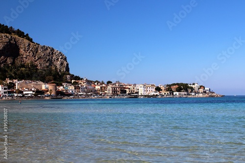 evocative image of the historic center of Mondello with its characteristic tower, the crystalline sea and the Capo Gallo reserve