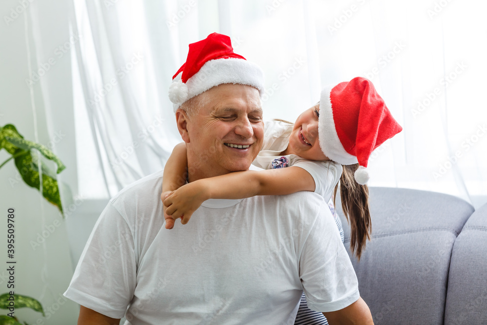 Obraz premium Happy childhood. Child enjoy christmas with Santa claus. Granddaughter spend time with grandpa. Christmas eve. Family.