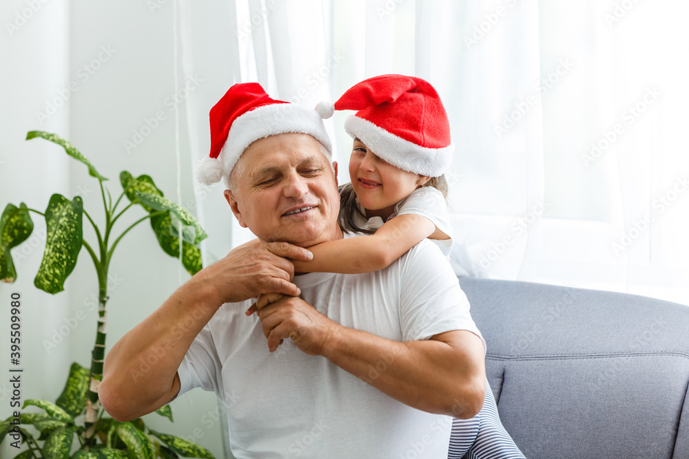 Obraz premium Happy childhood. Child enjoy christmas with Santa claus. Granddaughter spend time with grandpa. Christmas eve. Family.