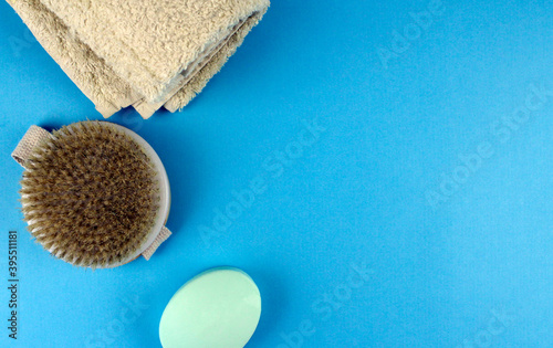 Soap, towel and body brush. Hygiene products on a blue background.