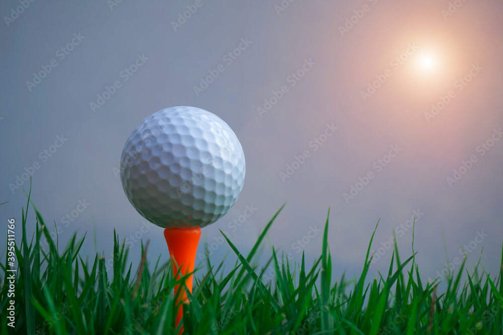 Golf ball on tee in beautiful golf course at sunset background Golf ball on tee in beautiful golf course at sunset background