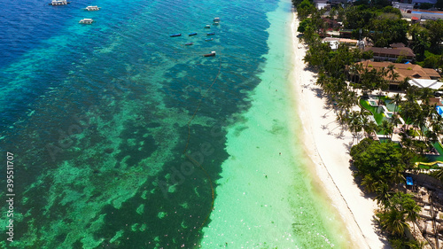 Beautiful tropical beach with white sand, palm trees, turquoise ocean. Alona beach, Panglao island, Bohol, Philippines.