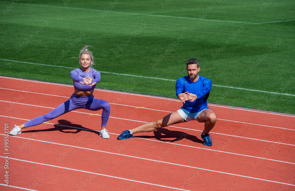 healthy lifestyle. muscle flexibility. sport couple stretching. fitness partners warming up. athletic man and sexy woman training. male and female coach on stadium do squat lunge