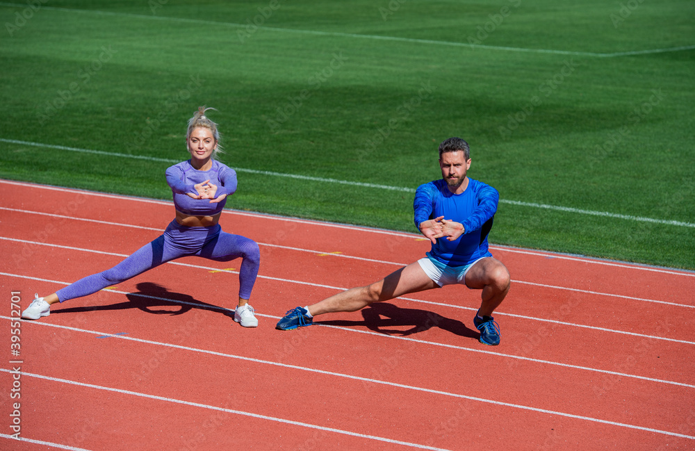 Obraz premium healthy lifestyle. muscle flexibility. sport couple stretching. fitness partners warming up. athletic man and sexy woman training. male and female coach on stadium do squat lunge
