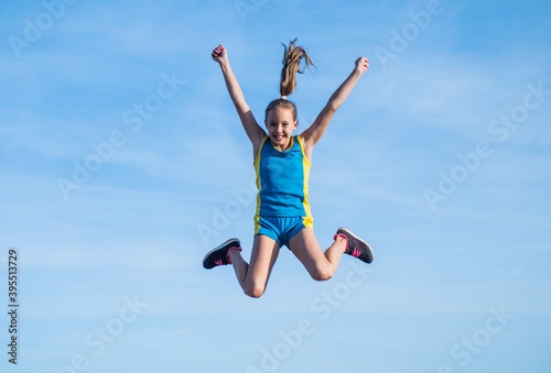 happy kid in sport training clothes jumping outdoor, happiness