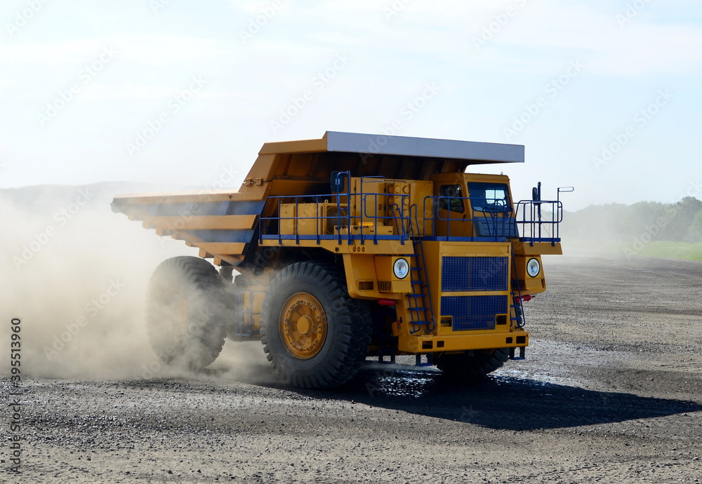 Mining dump truck transports useful minerals in open pit.