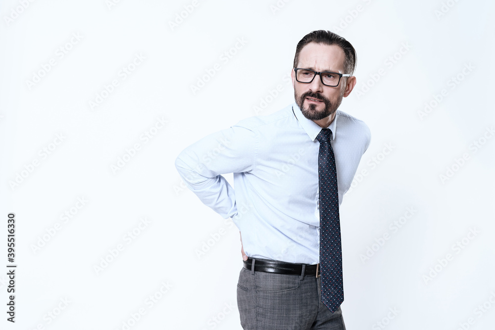 A man in a white shirt with severe back pain. A man in a white shirt with severe back pain.