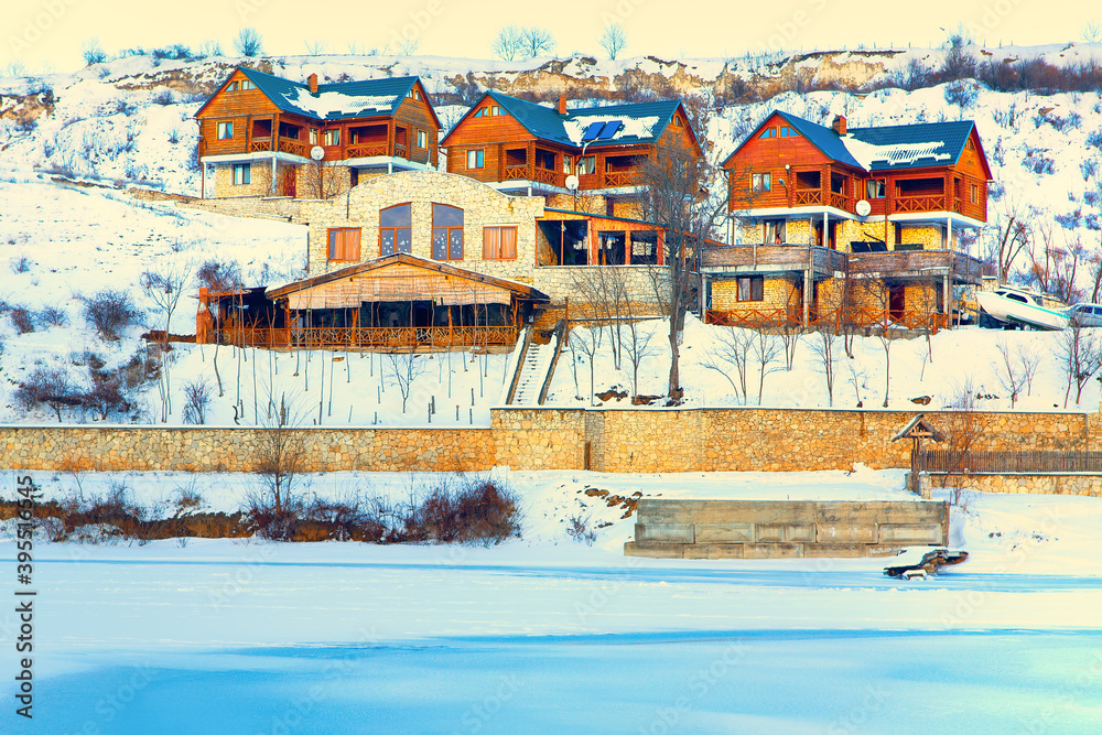 Tourist resort for winter vacations . Wooden cottages on the snowy hill 