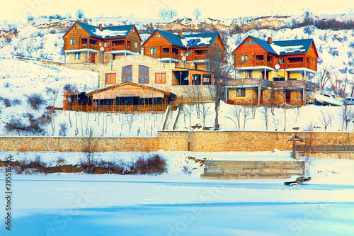 Tourist resort for winter vacations . Wooden cottages on the snowy hill 