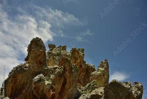 A group of rocks looking like gargoyles against dramatic clouds and a blue sky