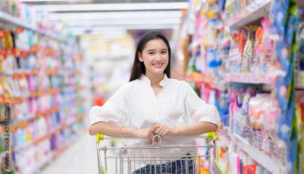 Smiling happy woman enjoying shopping at the supermarket.Young woman shopping at the supermarket