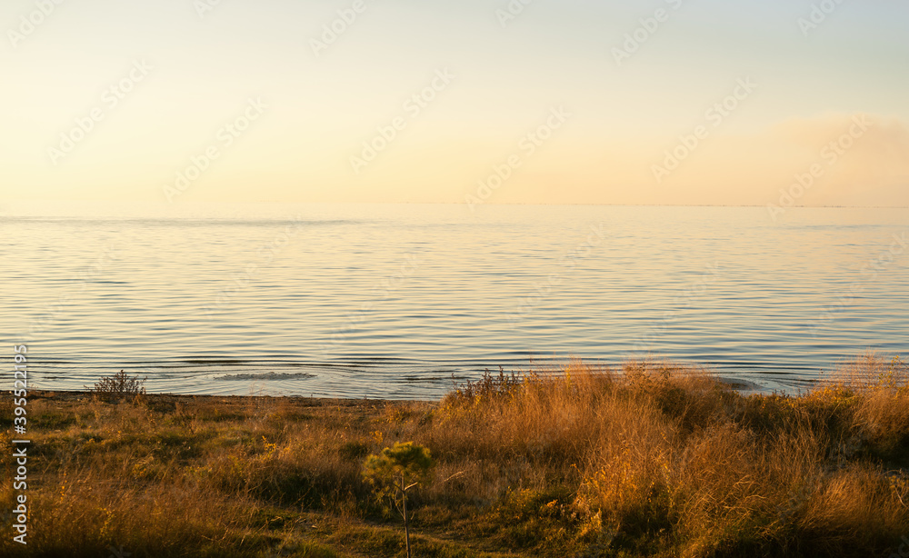 Autumnal beach with calm sea at sunset