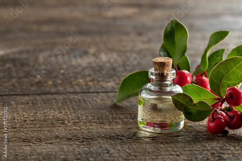 A bottle of essential oil with fresh wintergreen