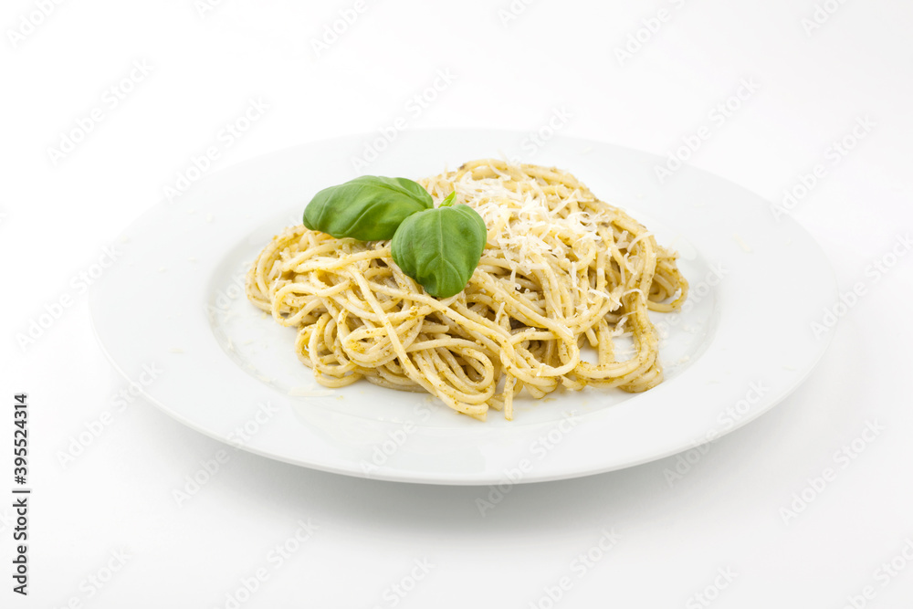 Homemade carbonara served on a white pate, topped with basil leafs and grated parmesan. Studio photo isolated on white background.