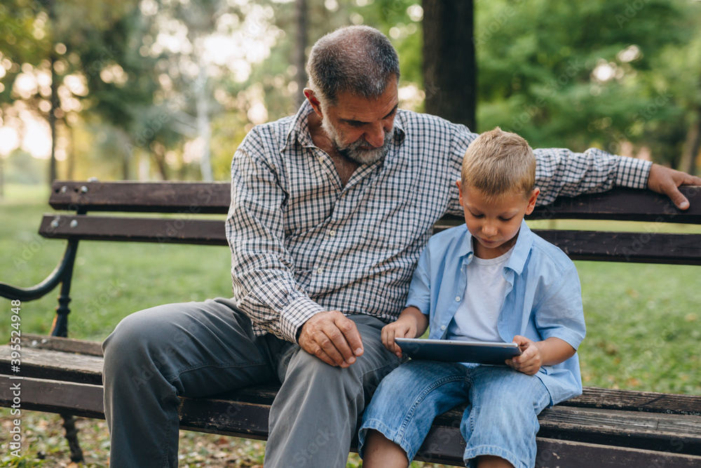 Obraz premium grandfather and grandson spending time together in public park