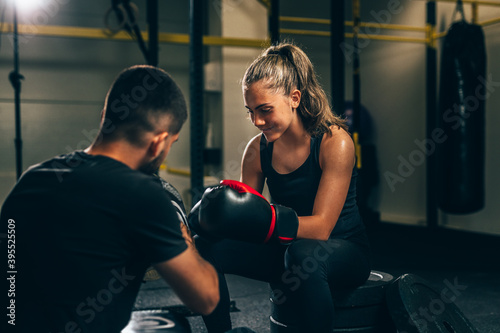 young woman preparing for boxing training with her trainer