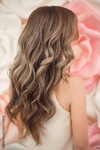 Beautiful long wavy hair style. Bride wedding hairstyle over flowers copyspace. Beauty hairdressing salon.
