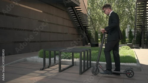 Young businessman is riding electric scooter to work