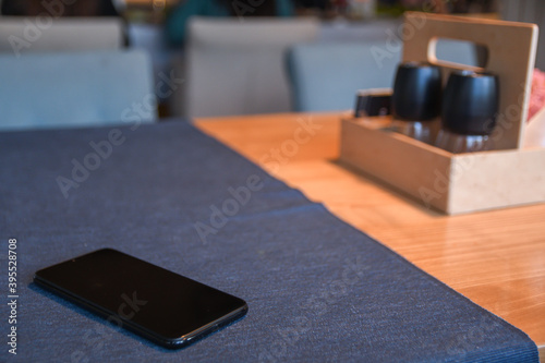 Cellphone on the table in cafe with beautiful blurred background