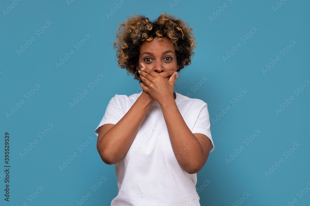 Φωτογραφία Beautiful young african woman covering the mouth with her hand,trying to keep secret