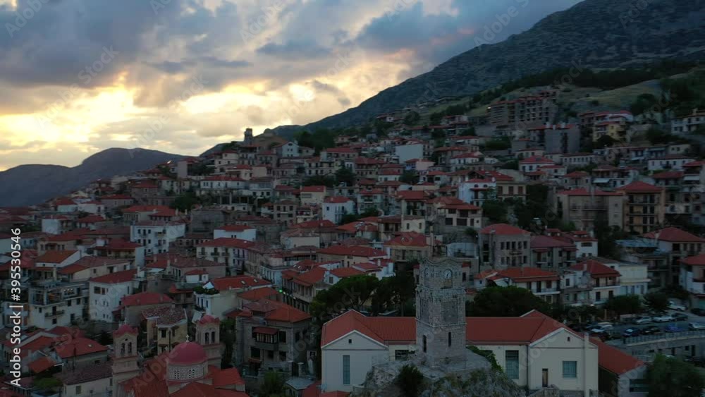 Aerial drone video of beautiful sunset with golden colours and clouds over old landmark clock tower in picturesque and traditional village of Arachova, Viotia prefecture, Greece Aerial drone video of beautiful sunset with golden colours and clouds over old landmark clock tower in picturesque and traditional village of Arachova, Viotia prefecture, Greece