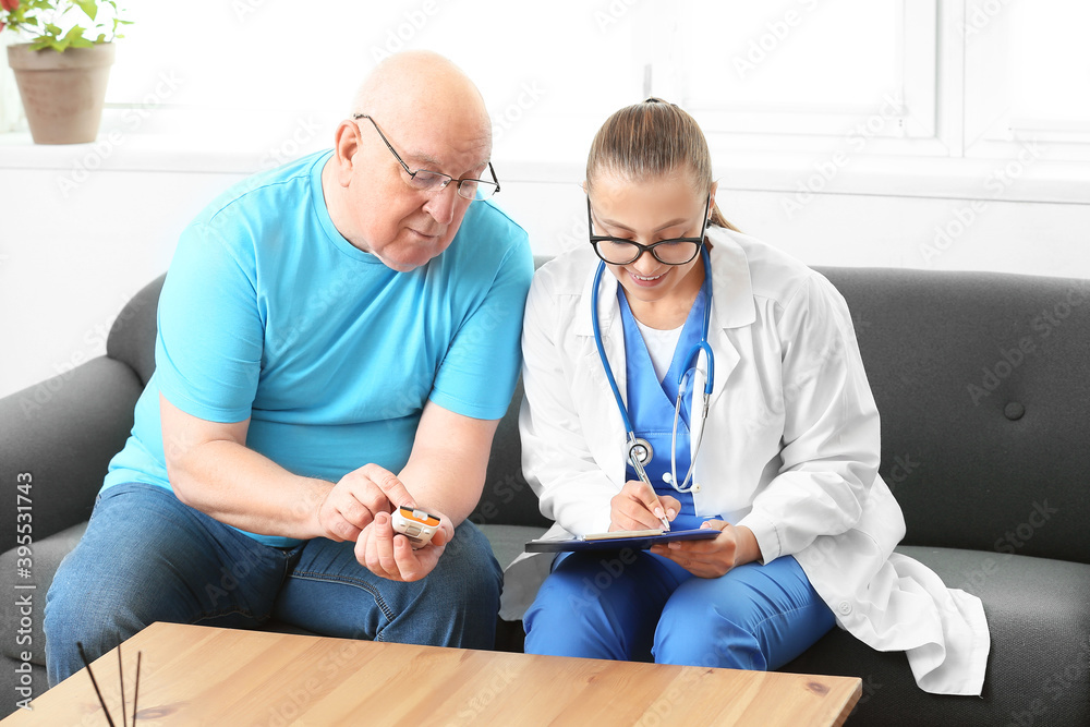 Obraz premium Doctor visiting senior diabetic man at home