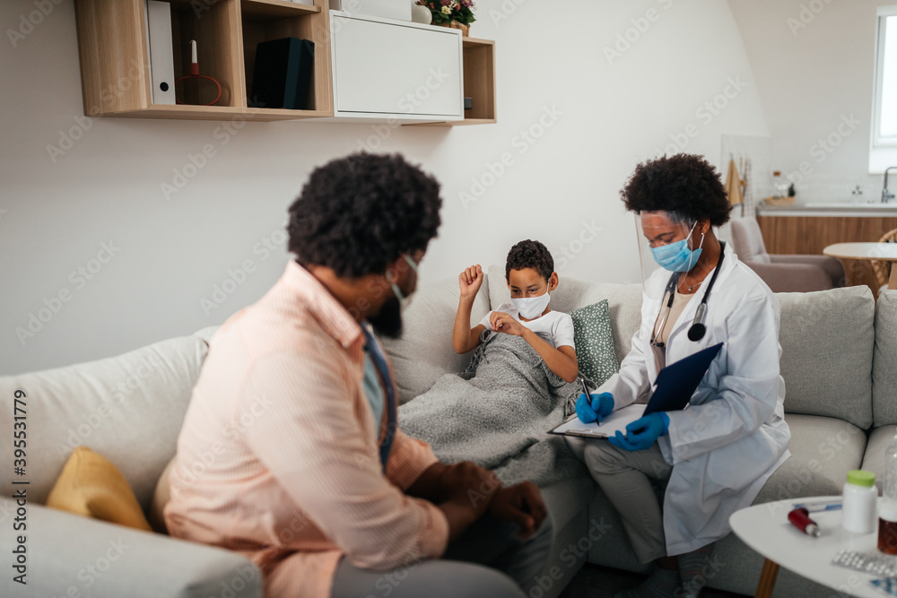 Female doctor visiting father and son at home Female doctor visiting father and son at home