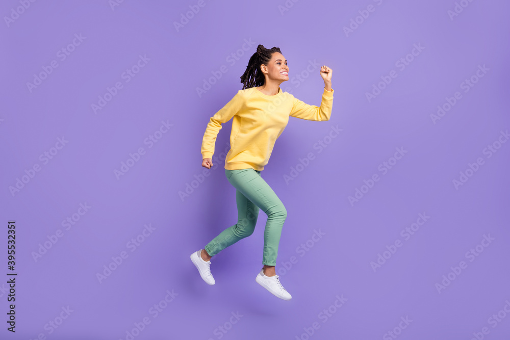 Full size profile photo of optimistic girl jump wear yellow shirt trousers sneakers isolated on lilac color background