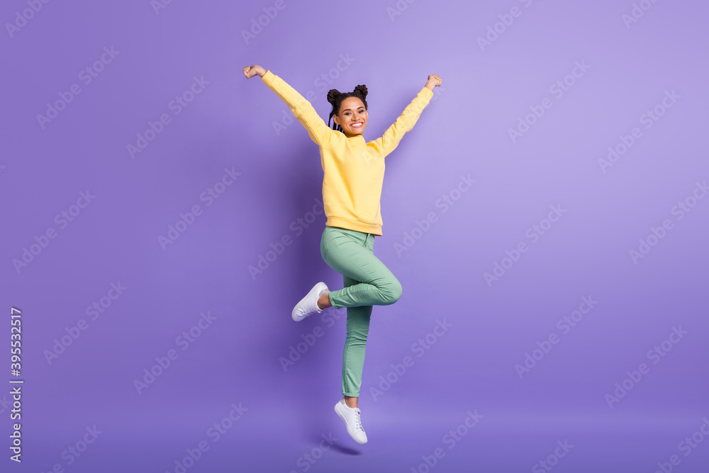 Full size photo of optimistic cute girl jump wear yellow shirt trousers sneakers isolated on lilac color background