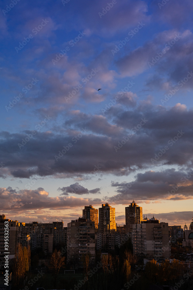Sunset in the city. Clouds over the city of Kyiv. Metropolis background vertical. 