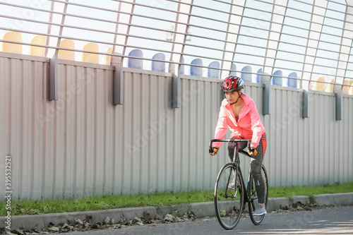 Fototapeta Naklejka Na Ścianę i Meble -  Female cyclist riding bicycle outdoors