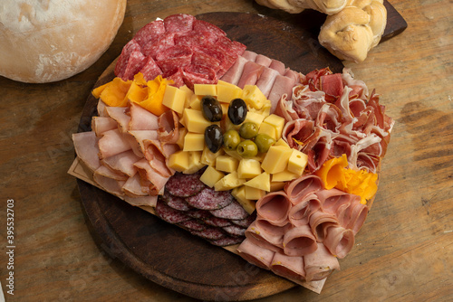 table of cold cuts and various cheeses with olives, homemade bread chopped with loin, ham, bondiola, bacon, salami, and a variety of cheeses photo