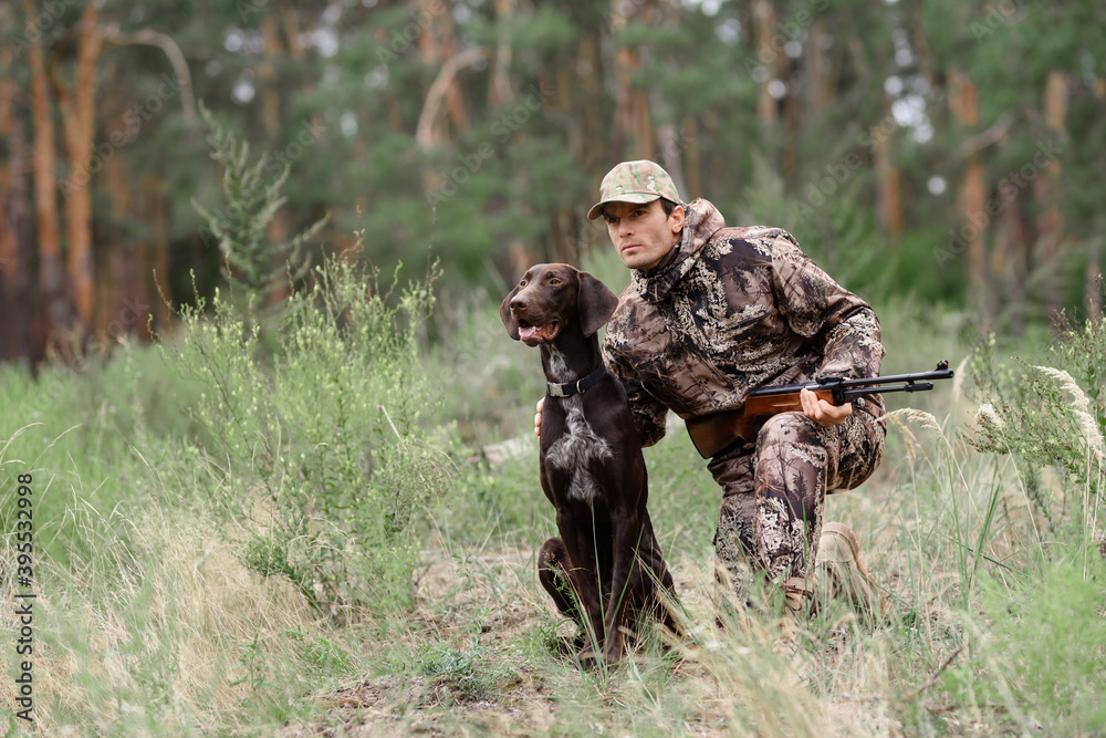 Alert Hunter and Dog in Forest Animal Chasing. - obrazy, fototapety, plakaty 
