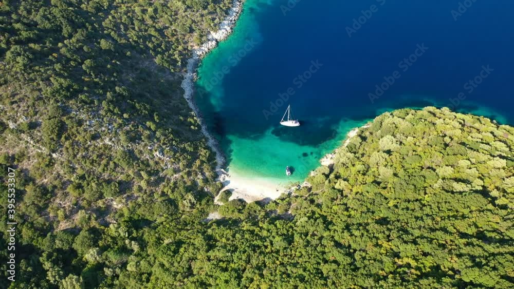 Aerial drone video of tropical paradise exotic island covered in pine trees with turquoise crystal clear beach in Caribbean destination