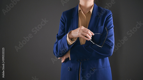 Cropped view of business woman holding black rimmed glasses in her hands.Space for text