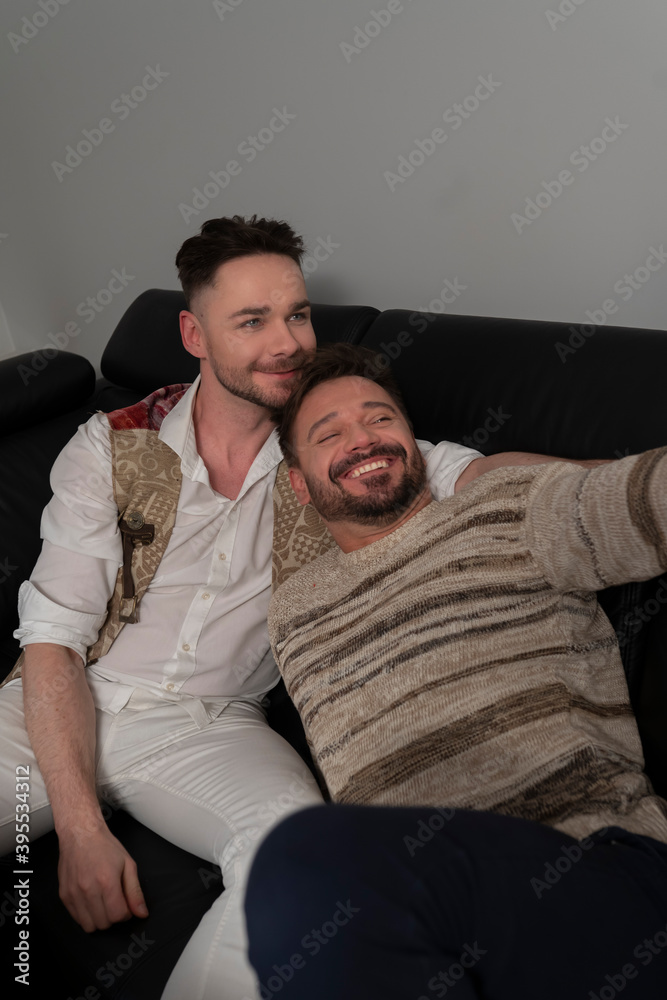Young romantic male gay couple using smartphone for video call. High quality photo