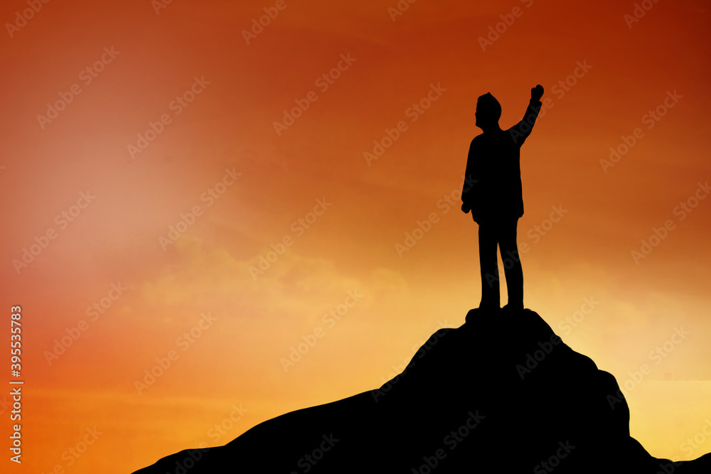 Silhouette of Businessman stand on the top of hill , achievement , success and leadership concept.