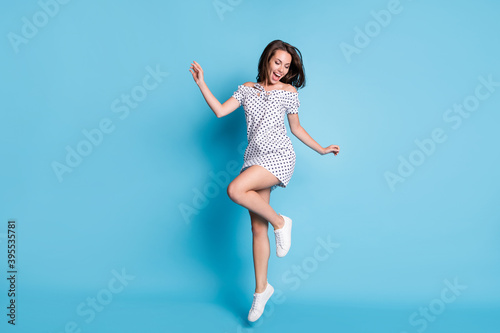 Fototapeta Naklejka Na Ścianę i Meble -  Photo of young charming girl jump open mouth wear dotted mini dress footwear isolated blue color background
